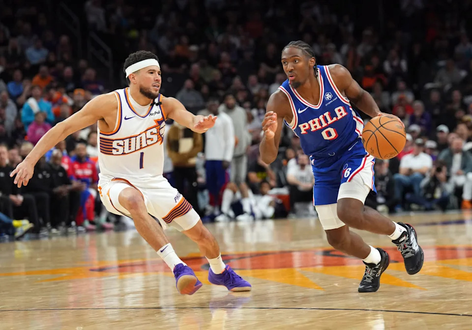 Nov 4, 2024; Phoenix, Arizona, USA; Philadelphia 76ers guard Tyrese Maxey (0) dribbles against Phoenix Suns guard Devin Booker (1) during the second half at Footprint Center. Mandatory Credit: Joe Camporeale-Imagn Images