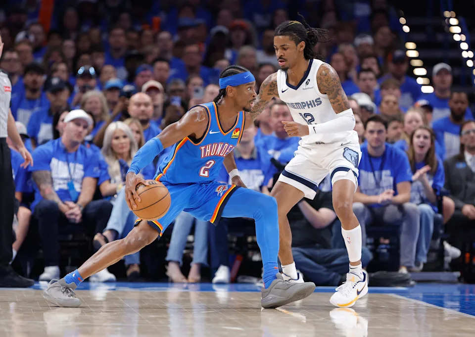 Apr 22, 2025; Oklahoma City, Oklahoma, USA; Oklahoma City Thunder guard Shai Gilgeous-Alexander (2) drives to the basket as Memphis Grizzlies guard Ja Morant (12) defends in the third quarter during game two of first round for the 2024 NBA Playoffs at Paycom Center. Mandatory Credit: Alonzo Adams-Imagn Images