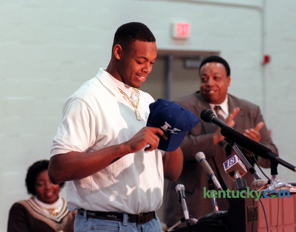 Dennis Johnson puts on a University of Kentucky hat after announcing that he would sign with the Wildcats to play football during a signing day press conference on Wed. Feb. 4, 1998, at Harrodsburg High School - Photo by Frank Anderson | Lexington Herald-Leader Staff