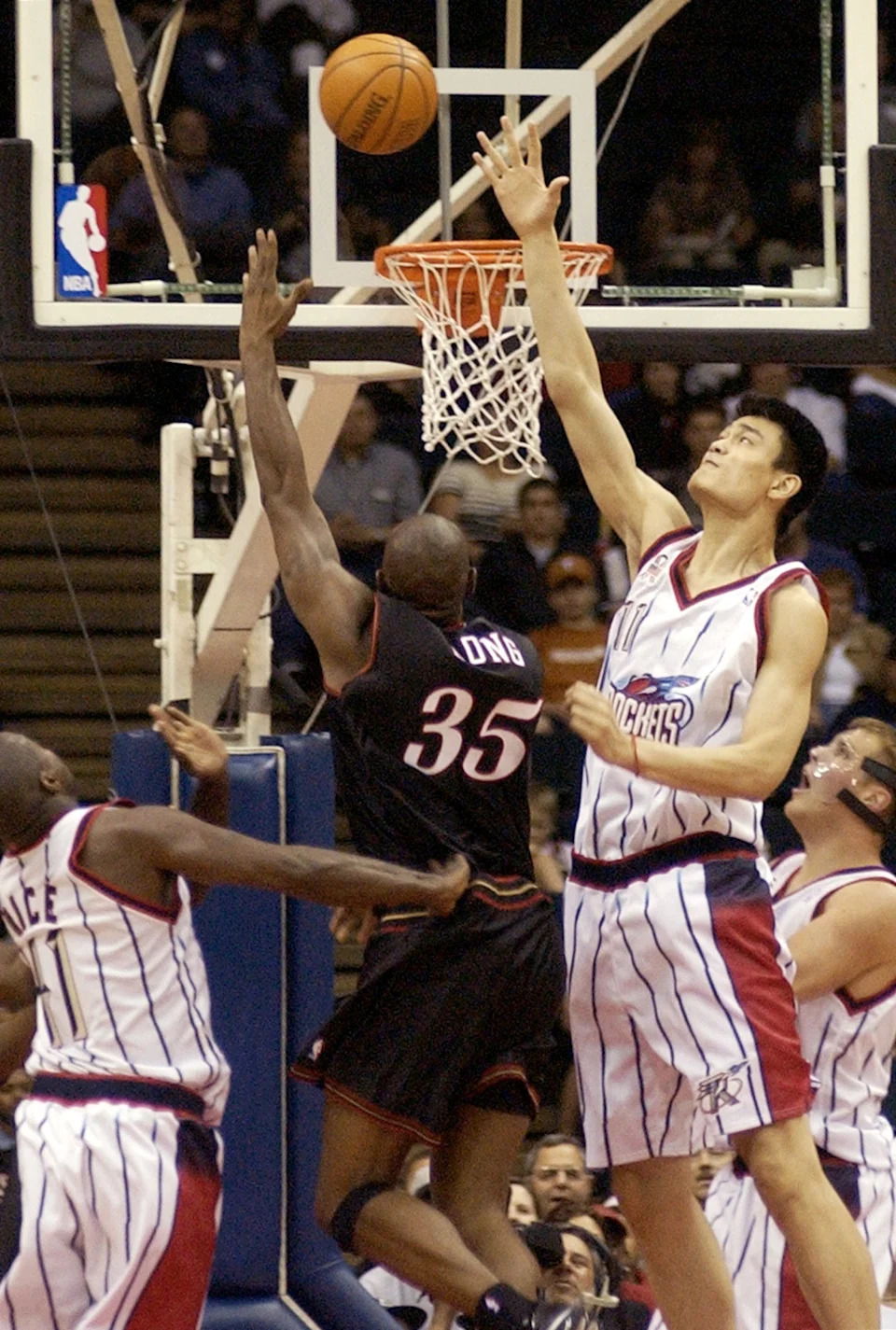 Houston Rockets' Yao Ming (R) reaches up to block the shot of Philadelphia 76ers' Art Long during the second quarter of their pre-season game at the Compaq Center in Houston, Texas 24 October 2002. AFP PHOTO/Brett COOMER (Photo by BRETT COOMER / AFP) (Photo by BRETT COOMER/AFP via Getty Images)