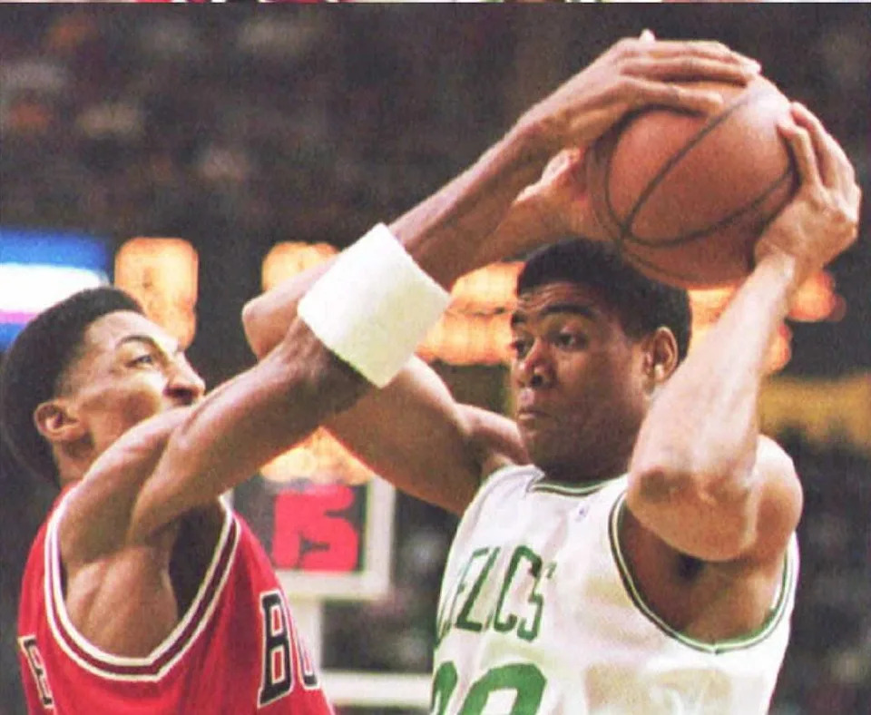 BOSTON, : Pervis Ellison (R) of the Boston Celtics is slowed down by Scottie Pippen of the Chicago Bulls in the first quarter 28 December at the Boston Garden. Chicago led for most of the first half. (COLOR KEY: Pippen wears red.) (Photo credit should read JOHN MOTTERN/AFP via Getty Images)