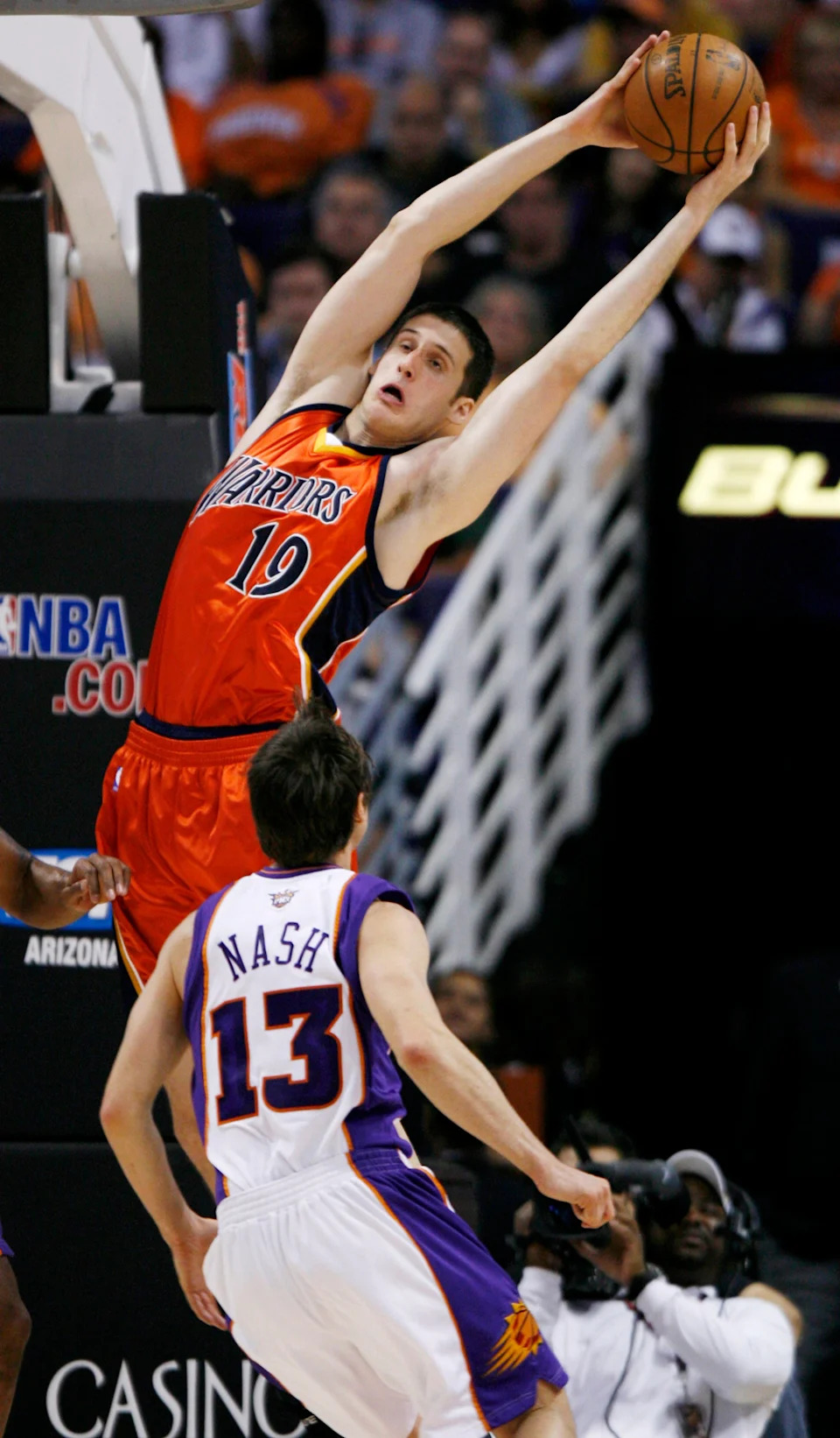 Golden State Warriors Kosta Perovic (19) grabs a rebound as Phoenix Suns Steve Nash (13) looks on during first quarter NBA basketball action in Phoenix, Arizona, April 14, 2008. REUTERS/Jeff Topping (UNITED STATES)
