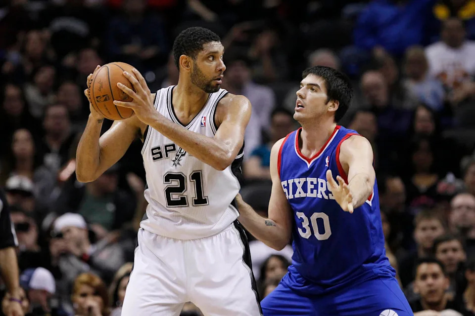 Mar 24, 2014; San Antonio, TX, USA; San Antonio Spurs forward Tim Duncan (21) is defended by Philadelphia 76ers center Byron Mullens (30) during the first half at AT&T Center. Mandatory Credit: Soobum Im-USA TODAY Sports