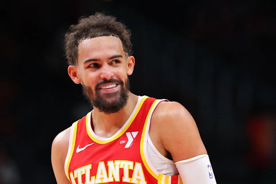 Trae Young of the Atlanta Hawks smiles at the bench during opening night against the Brooklyn Nets at State Farm ArenaKevin C. Cox/Getty Images