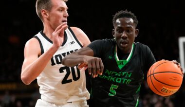Deng Mayar (5) drives past Iowa forward Payton Sandfort (20) during the first half of an NCAA college basketball game on Nov. 7, 2023, in Iowa City, Iowa.