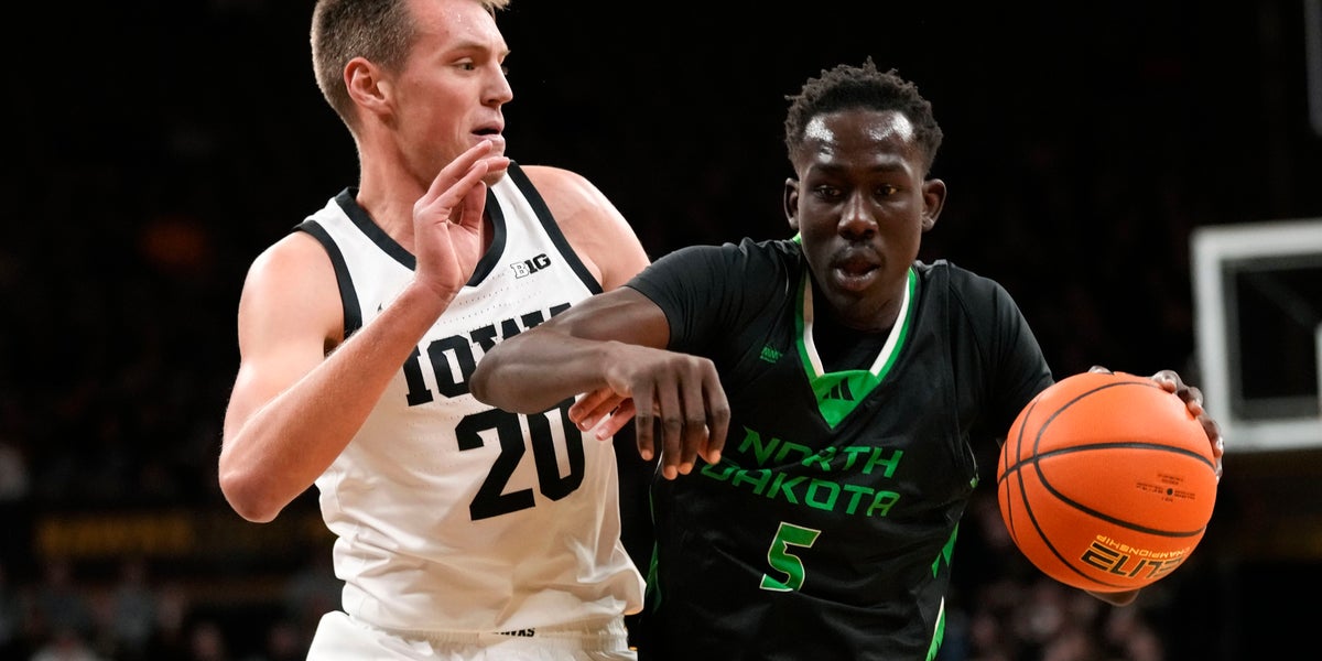 Deng Mayar (5) drives past Iowa forward Payton Sandfort (20) during the first half of an NCAA college basketball game on Nov. 7, 2023, in Iowa City, Iowa.