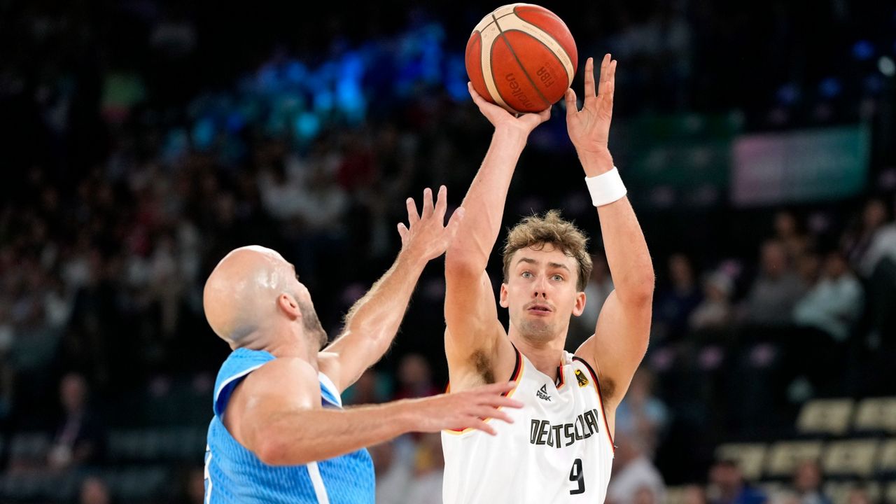 Magic forward Franz Wagner (right), playing for his native Germany, shoots as former Gsators guard Nick Calathes, of Greece, defends during a men's basketball game at the 2024 Summer Olympics, Tuesday, Aug. 6, 2024, in Paris, France. (AP Photo/Michael Conroy)