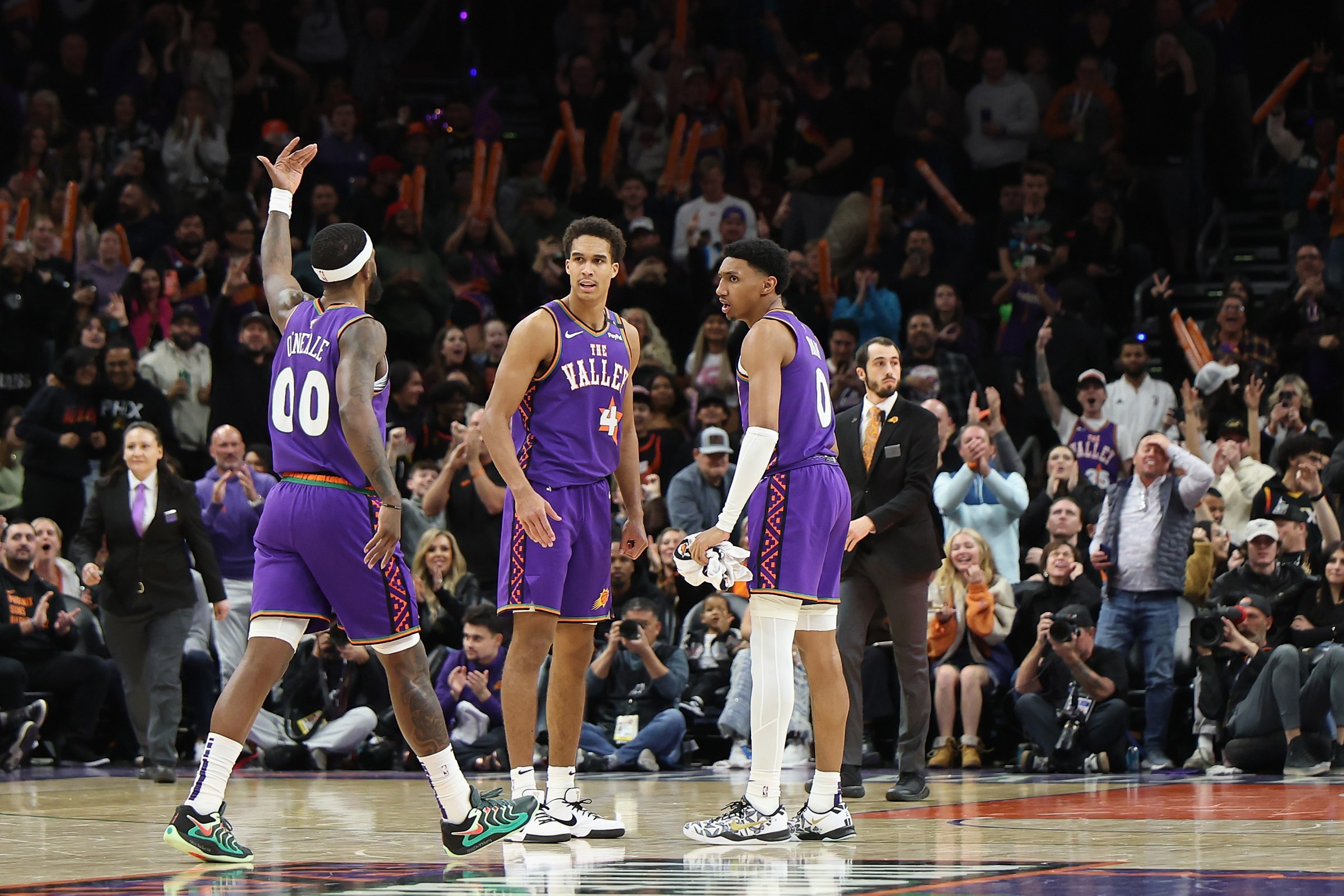 PHOENIX, ARIZONA - JANUARY 12: Royce O’Neale #00 of the Phoenix Suns celebrates with Oso Ighodaro #4 and Ryan Dunn #0 after hitting a three-point shot during the final moments of the NBA game at Footprint Center on January 12, 2025 in Phoenix, Arizona. The Suns defeated the Hornets 120-113. NOTE TO USER: User expressly acknowledges and agrees that, by downloading and or using this photograph, User is consenting to the terms and conditions of the Getty Images License Agreement. (Photo by Christian Petersen/Getty Images)