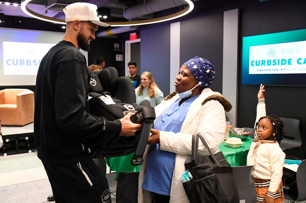 Derrick White gifts mothers car seats at a Curbside Care program event in January.