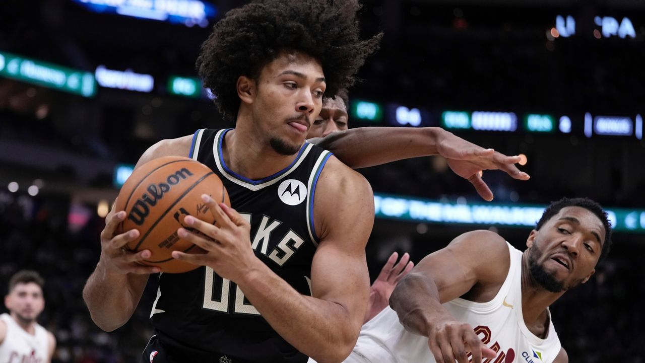 Milwaukee Bucks' Jericho Sims grabs a rebound in front of Cleveland Cavaliers' Donovan Mitchell during the first half of an NBA basketball game Sunday, Mar. 9, 2025, in Milwaukee.