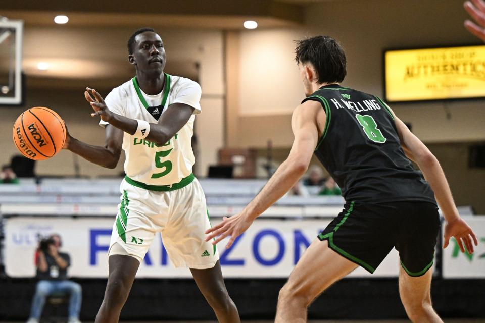 Basketball player dribbling the ball while being defended.