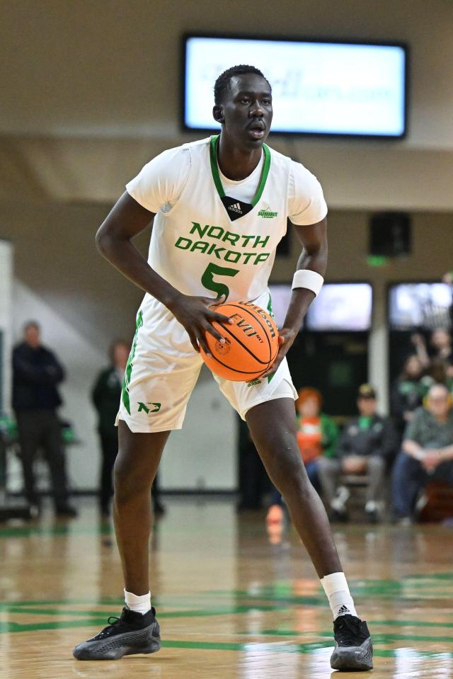 North Dakota Fighting Hawks basketball player Deng Mayar (5) dribbling the ball.