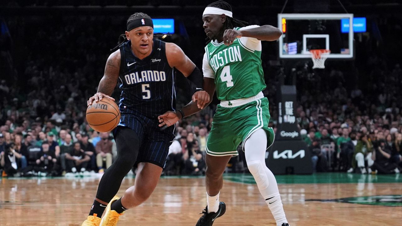 Orlando Magic forward Paolo Banchero (5) drives to the basket against Boston Celtics guard Jrue Holiday (4) during the first half in game 2 of a first-round NBA playoff basketball series, Wednesday, April 23, 2025, in Boston. (AP Photo/Charles Krupa)