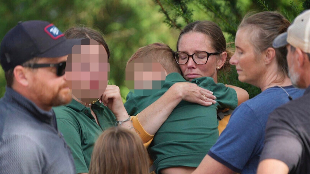 Guardian with students after a mass shooting at a catholic school.