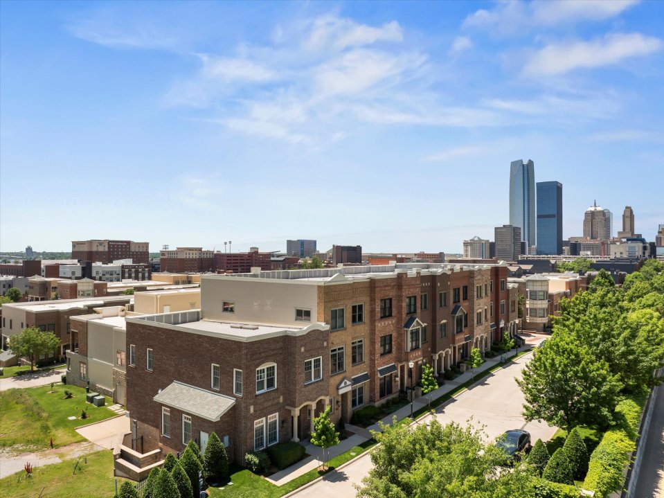 Aerial view of townhouses in Oklahoma City with the city skyline in the background.
