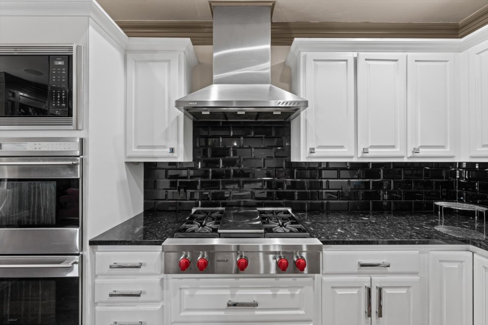Kevin Durant's former Oklahoma City townhouse kitchen, featuring Wolf appliances and black tile backsplash.