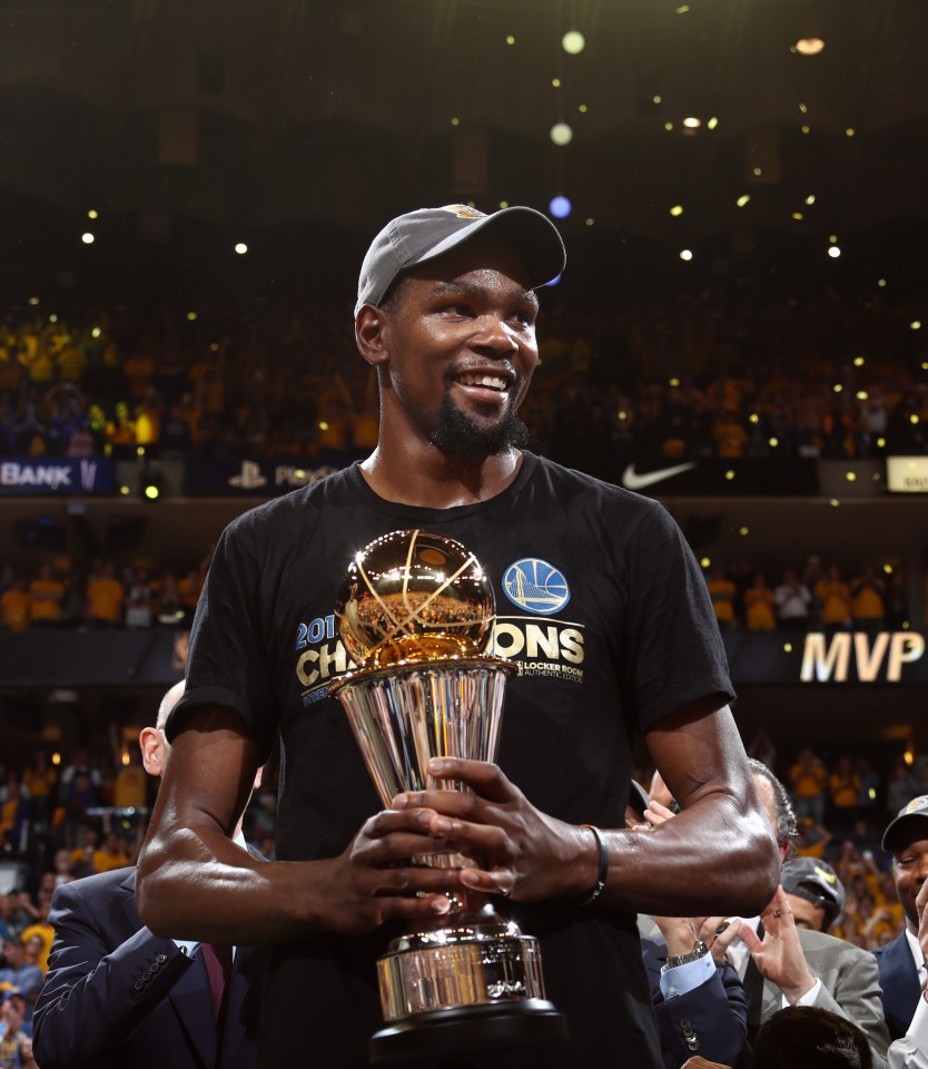 Kevin Durant holding the Bill Russell Finals MVP trophy.