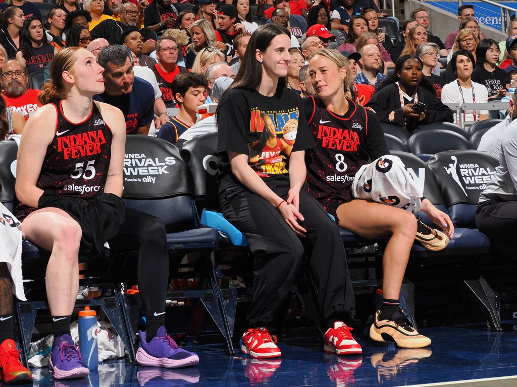 Indiana Fever players sitting courtside.