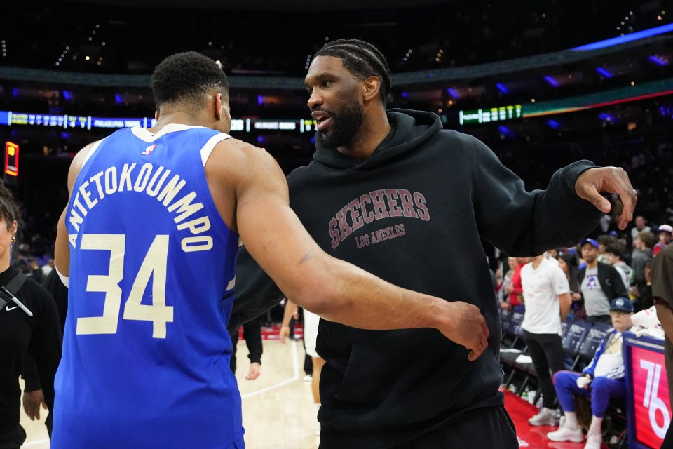 Giannis Antetokounmpo and Joel Embiid talking after a basketball game.