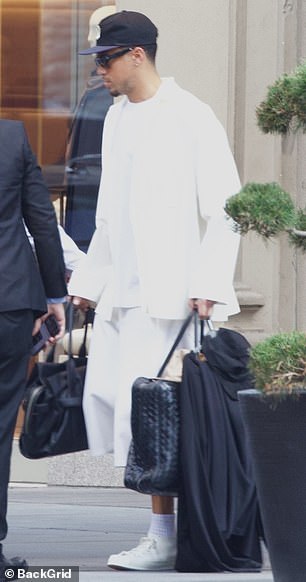 Devin carried two black bags and a black garment as he headed toward a waiting SUV