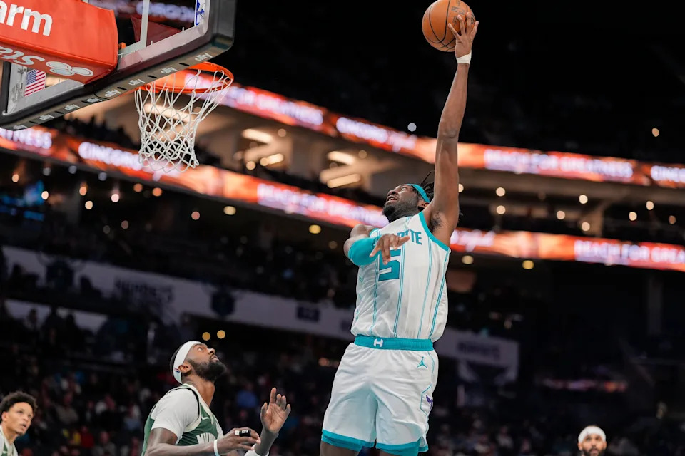 Feb 5, 2025; Charlotte, North Carolina, USA; Charlotte Hornets center Mark Williams (5) lays in the basket over Milwaukee Bucks forward Bobby Portis (9) during the second half at Spectrum Center. Mandatory Credit: Jim Dedmon-Imagn Images