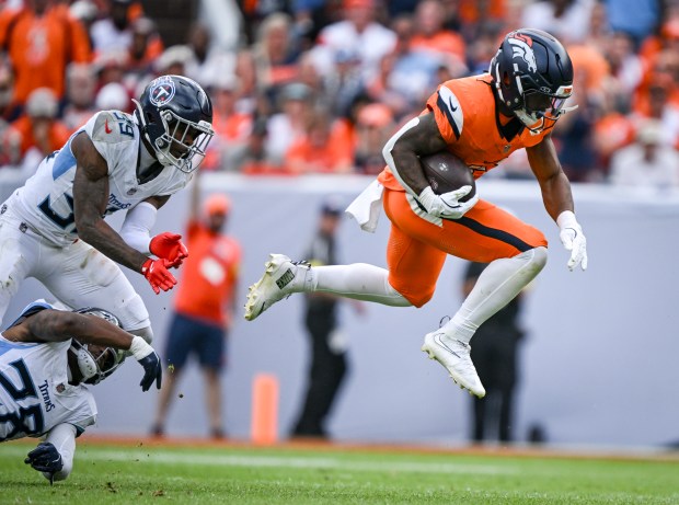 RJ Harvey (12) of the Denver Broncos breaks free of Darrell Baker Jr. (39) and Quandre Diggs (28) of the Tennessee Titans for a 50-yard run during the fourth quarter of the Broncos' 20-12 win at Empower Field at Mile High on Sunday, Sept. 7, 2025. (Photo by AAron Ontiveroz/The Denver Post)