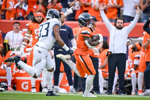 RJ Harvey (12) of the Denver Broncos runs ahead of Cedric Gray (33) of the Tennessee Titans for a 50-yard run during the fourth quarter of the Broncos' 20-12 win at Empower Field at Mile High on Sunday, Sept. 7, 2025. (Photo by AAron Ontiveroz/The Denver Post)