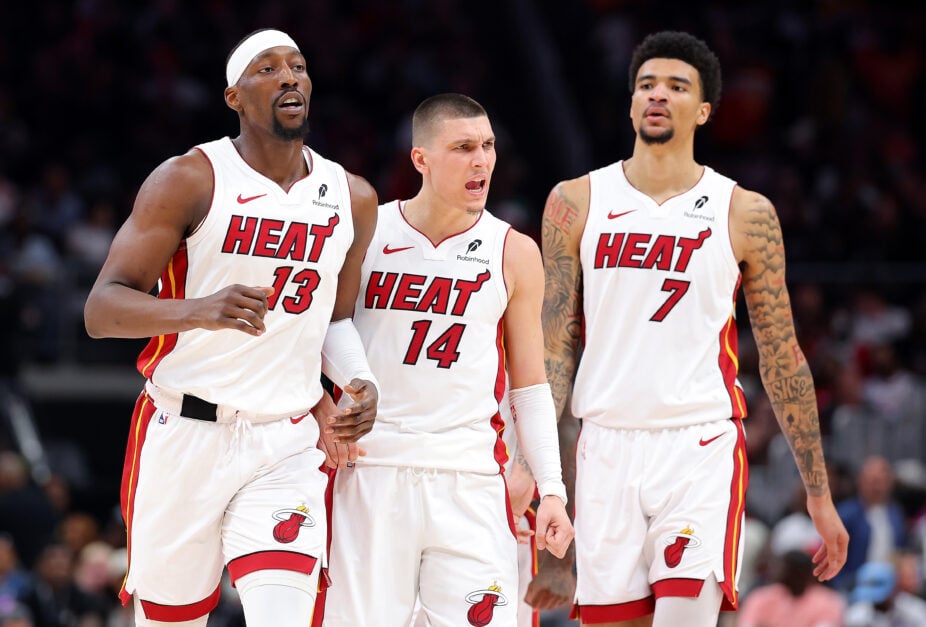 Bam Adebayo #13, Tyler Herro #14 and Kel'el Ware #7 of the Miami Heat react against the Atlanta Hawks during the third quarter of an NBA play-in tournament game.