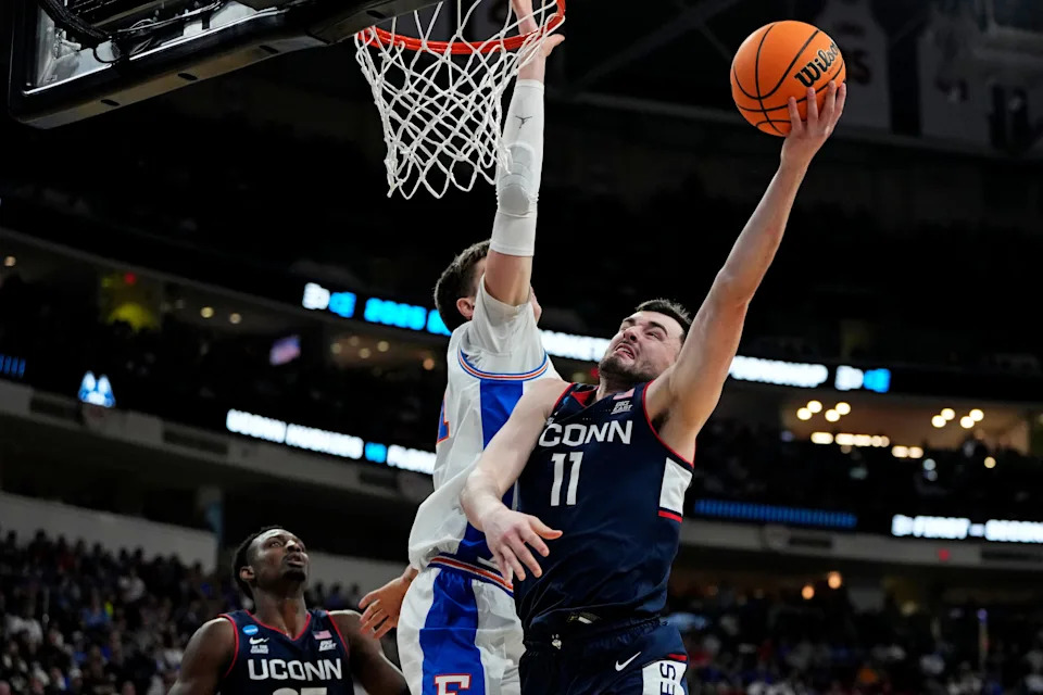 Mar 23, 2025; Raleigh, NC, USA; Connecticut Huskies forward Alex Karaban (11) drives to the basket as Florida Gators forward Alex Condon (21) defends during the first half in the second round of the NCAA Tournament at Lenovo Center. Mandatory Credit: Bob Donnan-Imagn Images
