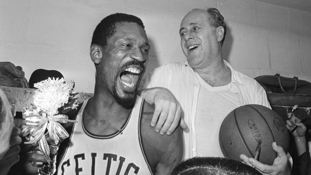 FILE - Boston Celtics' Bill Russell, left, holds a corsage sent to the dressing room as he celebrates with Celtics coach Red Auerbach after defeating the Los Angeles Lakers, 95-93, to win their eighth-straight NBA Championship, in Boston, in this April 29, 1966, photo. The NBA great Bill Russell has died at age 88. His family said on social media that Russell died on Sunday, July 31, 2022. Russell anchored a Boston Celtics dynasty that won 11 titles in 13 years. (AP Photo/File)