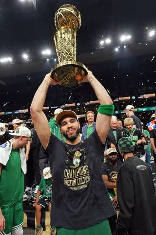 Jesse D. Garrabrant/NBAE via Getty Tatum lifting the NBA championship trophy after the Celtics beat the Dallas Mavericks in 2024