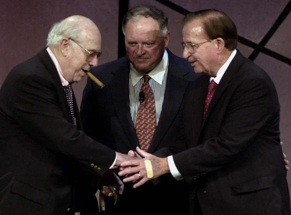 Morgan Wootten (R), who has been named Washington, DC, high school Basketball Coach of the Year ten times, is congratulated by former Boston Celtic's coach Red Auerbach (L) and Dave Gavit chairman of the board of the Basketball Hall of Fame (C) after Wootten was inducted into the 2000 Basketball Hall of Fame in Springfield, Massachusetts, Civic Center 13, October, 2000. Wootten is the high school coach with the most wins 1,213. (FILM) AFP PHOTO JOHN MOTTERN (Photo by JOHN MOTTERN / AFP) (Photo by JOHN MOTTERN/AFP via Getty Images)