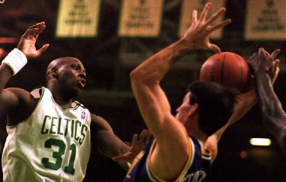 Xavier McDaniel (L) of the Boston Celtics breaks up an offensive play by John Stockton (R) of the Utah Jazz during the first half 17 December 1993. The Jazz defeated the Celtics, 97-96. (Photo by JOHN MOTTERN / AFP)  (Photo credit should read JOHN MOTTERN/AFP via Getty Images)