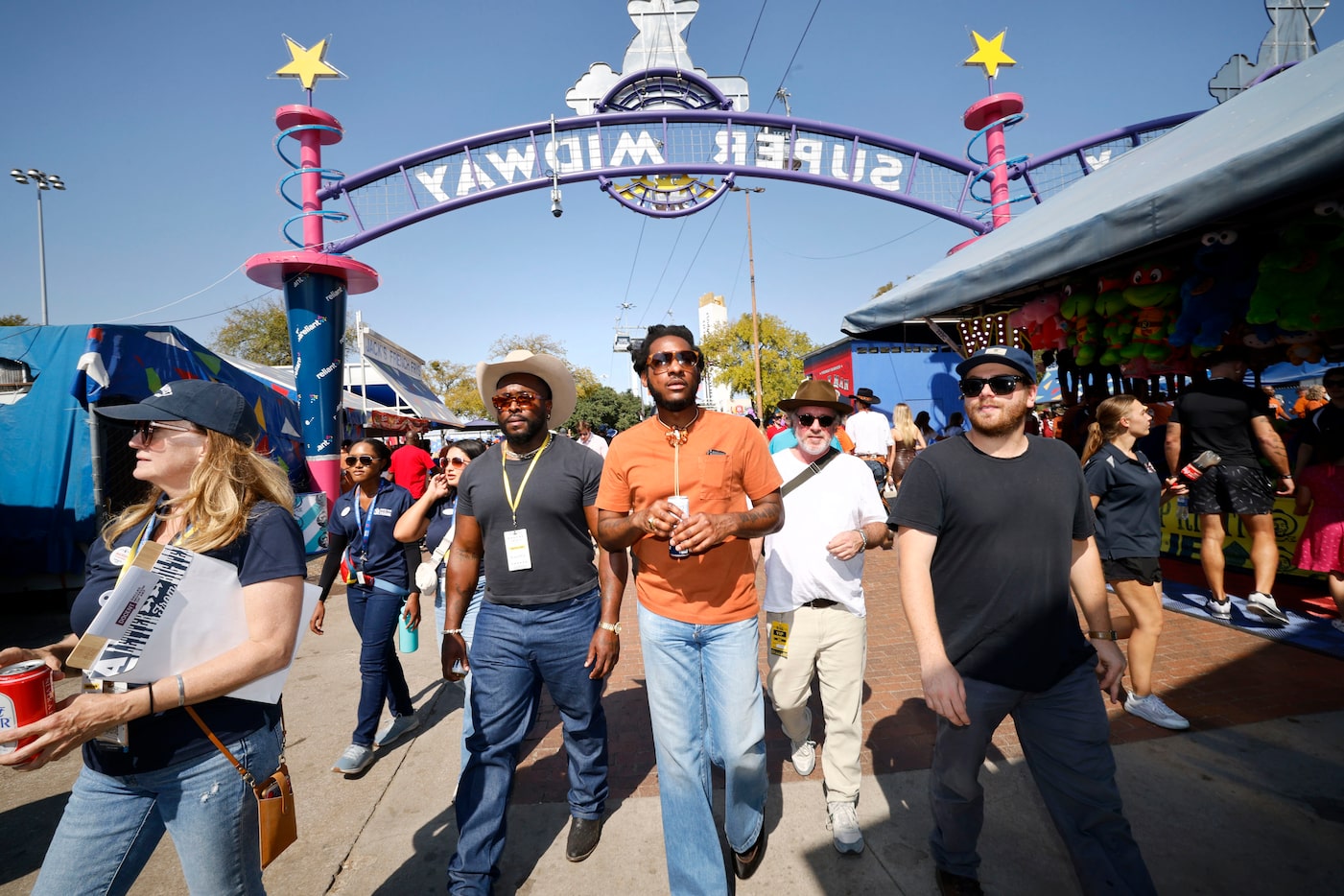 Musician Leon Bridges, center, walk through Super Midway at the State Fair of Texas,...