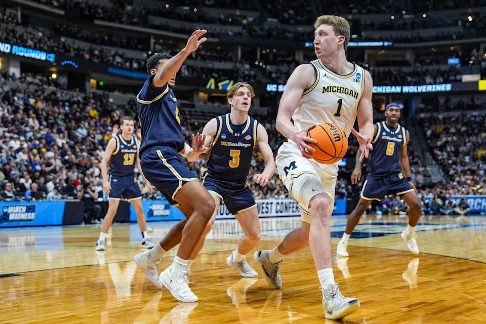 Michigan Wolverines center Danny Wolf (1) looks to pass the ball against UC San Diego Tritons guard Chris Howell (8) and guard Hayden Gray (3) during the second period of the first round of the NCAA tournament at Ball Arena in Denver, Colorado, Thursday, March 20, 2025.