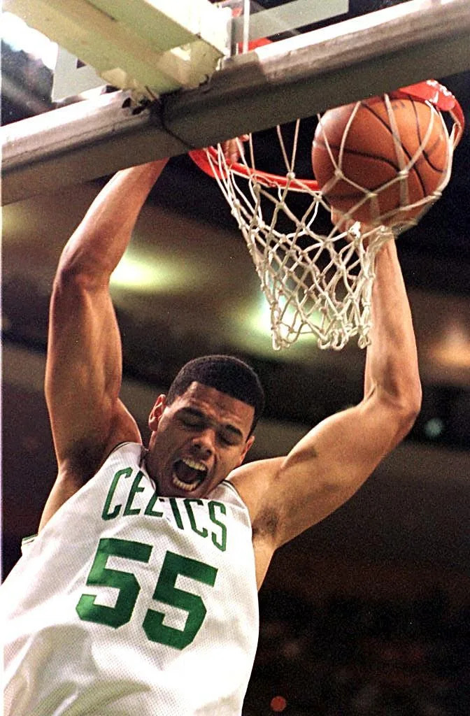 John Thomas of the Boston Celtics hangs on the hoop during the first half of action against the Seattle Supersonics at the Fleet Center in Boston 09 January. AFP PHOTO/John MOTTERN (Photo by JOHN MOTTERN / AFP) (Photo credit should read JOHN MOTTERN/AFP via Getty Images)