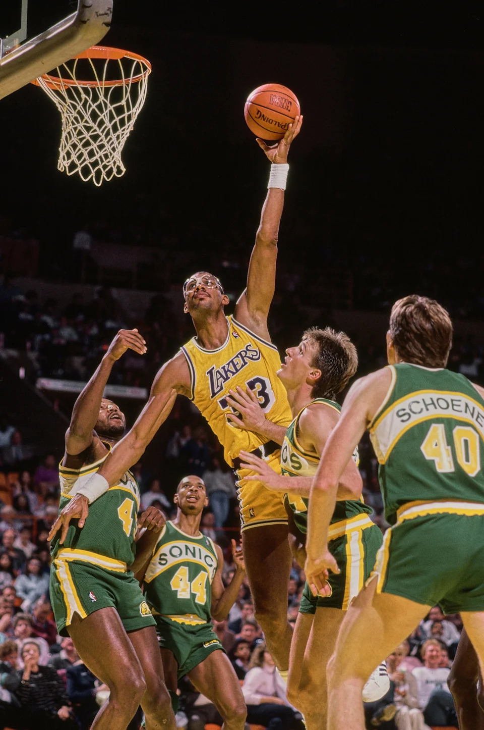 Kareem Abdul-Jabbar #33, Center for the Los Angeles Lakers jumps to make a one handed lay up shot to the basket as #40 Russ Schoene, #24 Tom Chambers #45 Clemon Johnson and #44 Terence Stansbury of the San Antonio Spurs look on during their NBA Pacific Division basketball game on 4th March 1987 at The Forum arena in Inglewood, Los Angeles, California, United States. The Los Angeles Lakers won the game 138 - 124. (Photo by Stephen Dunn/Allsport/Getty Images)