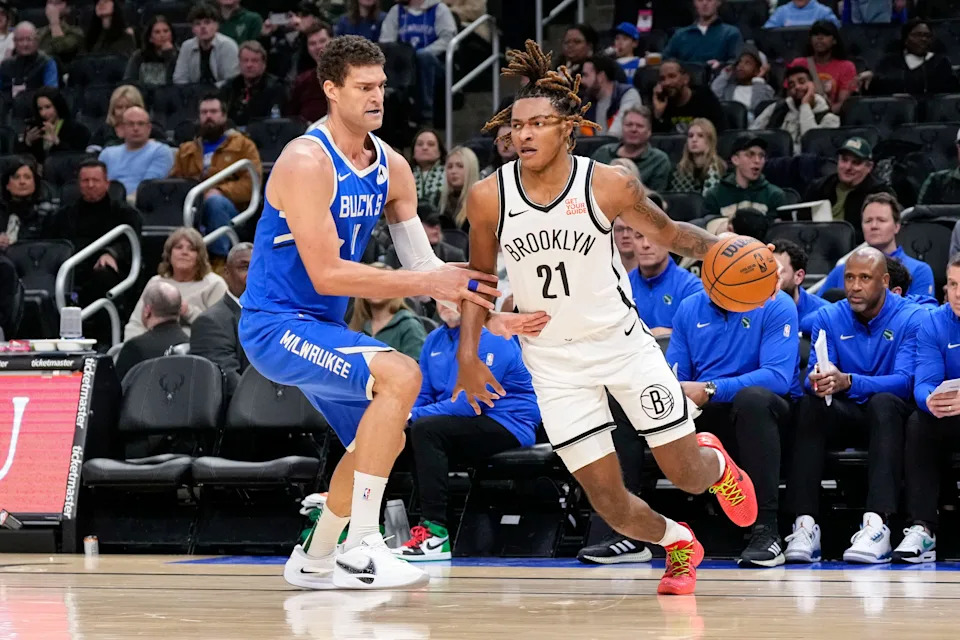 Dec 26, 2024; Milwaukee, Wisconsin, USA; Brooklyn Nets forward Noah Clowney (21) drives for the basket around Milwaukee Bucks center Brook Lopez (11) during the third quarter at Fiserv Forum. Mandatory Credit: Jeff Hanisch-Imagn Images