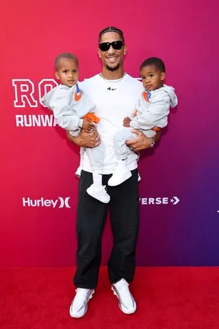 Jamie McCarthy/Getty  Josh Hart holds his twins, Haze and Hendrix Hart, on the red carpet of Macy's x Rookie Kids: 