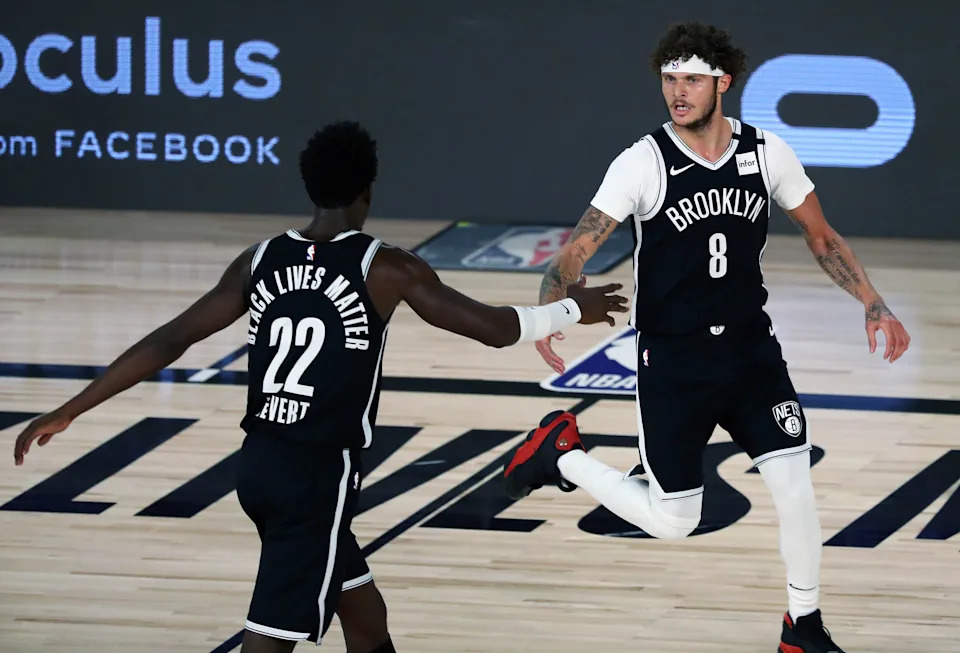 LAKE BUENA VISTA, FLORIDA - AUGUST 23: Tyler Johnson #8 of the Brooklyn Nets reacts with teammate Caris LeVert #22 after making a three point basket against the Toronto Raptors during the first half in game four of the first round of the NBA playoffs at The Field House at ESPN Wide World Of Sports Complex on August 23, 2020 in Lake Buena Vista, Florida. NOTE TO USER: User expressly acknowledges and agrees that, by downloading and or using this photograph, User is consenting to the terms and conditions of the Getty Images License Agreement. (Photo by Kim Klement-Pool/Getty Images)