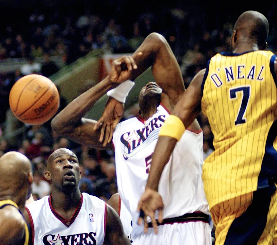 Philadelphia 76ers' center Dikembe Mutombo (C) recoils after being fouled by the Indiana Pacers' forward Jermaine O'Neal (R) before 76ers' forward Jumaine Jones (L) in the third quarter 01 April 2001 at the First Union Center in Philadelphia, PA. The 76ers won 104-93. AFP PHOTO/TOM MIHALEK (Photo by TOM MIHALEK / AFP) (Photo by TOM MIHALEK/AFP via Getty Images)