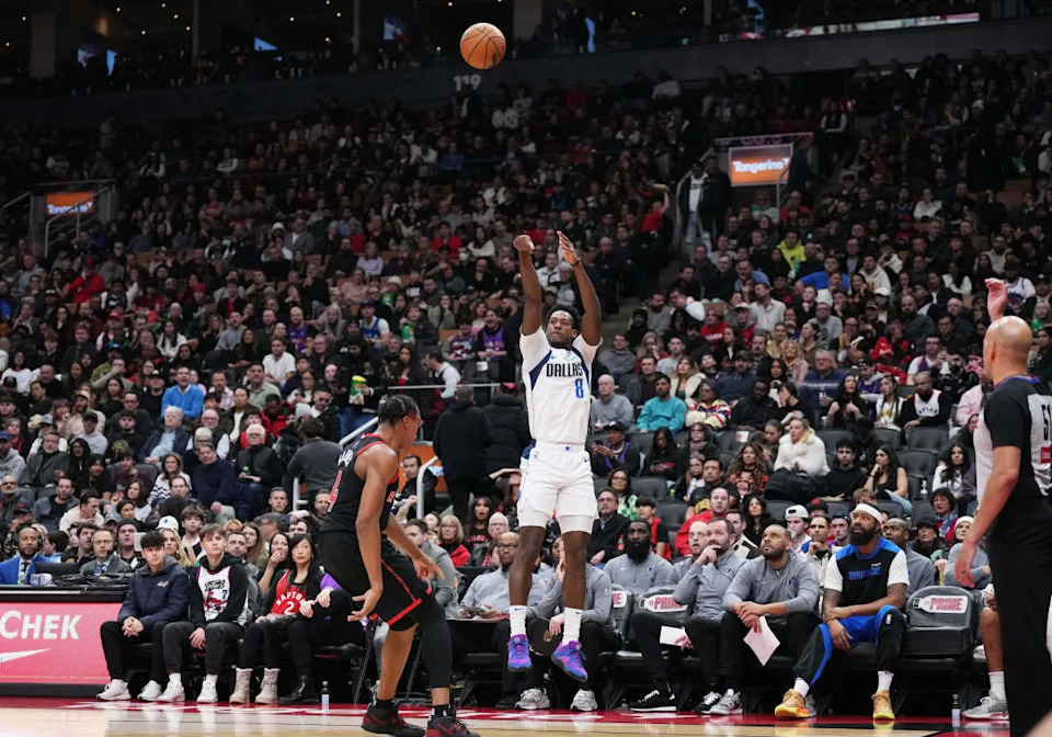 Dallas Mavericks forward Olivier-Maxence Prosper (8) shoots the ball at the basket over Toronto Raptors forward Scottie Barnes (4)© Nick Turchiaro-Imagn Images