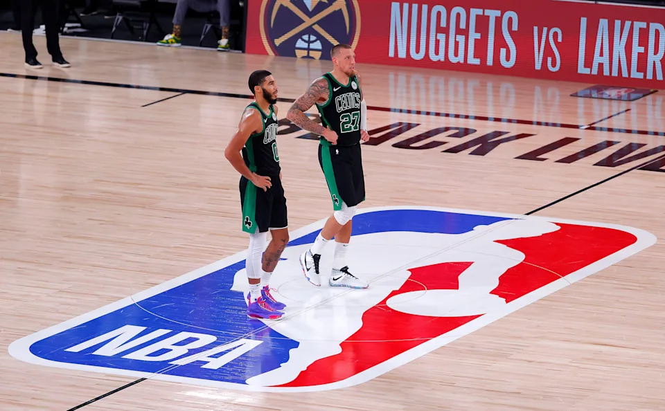 LAKE BUENA VISTA, FLORIDA - SEPTEMBER 25: Jayson Tatum #0 of the Boston Celtics and Daniel Theis #27 of the Boston Celtics react after their win over the Miami Heat in Game Five of the Eastern Conference Finals during the 2020 NBA Playoffs at AdventHealth Arena at the ESPN Wide World Of Sports Complex on September 25, 2020 in Lake Buena Vista, Florida. NOTE TO USER: User expressly acknowledges and agrees that, by downloading and or using this photograph, User is consenting to the terms and conditions of the Getty Images License Agreement. (Photo by Mike Ehrmann/Getty Images)