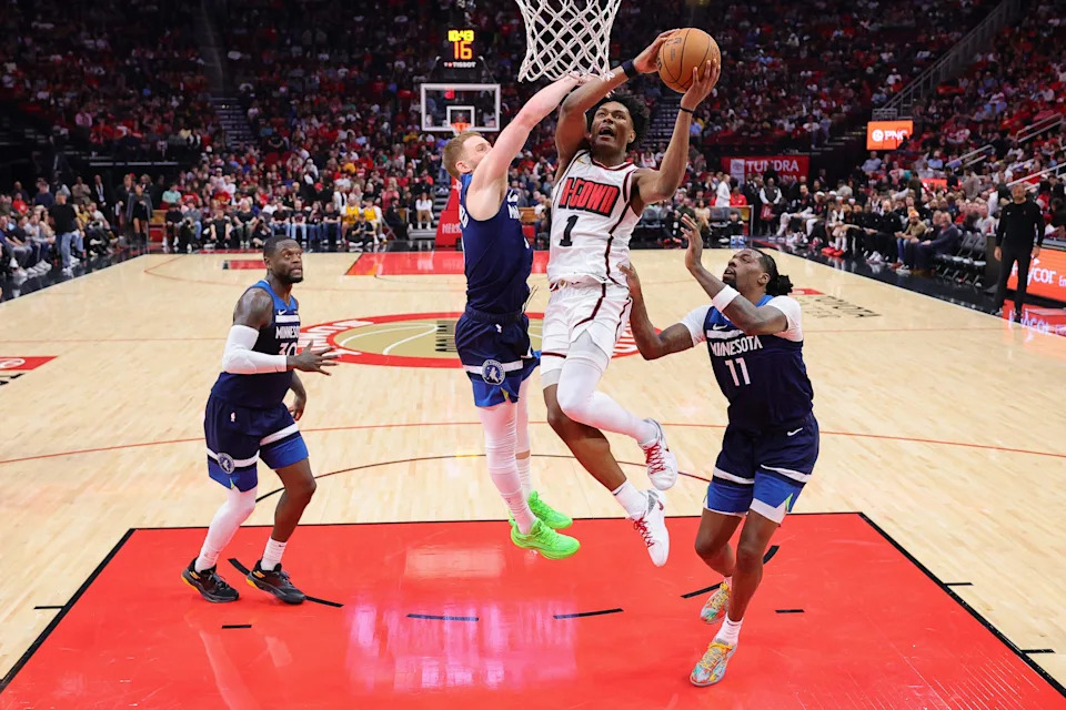 HOUSTON, TEXAS - DECEMBER 27: Amen Thompson #1 of the Houston Rockets shoots against Donte DiVincenzo #0 of the Minnesota Timberwolves during the first half at Toyota Center on December 27, 2024 in Houston, Texas. NOTE TO USER: User expressly acknowledges and agrees that, by downloading and or using this photograph, User is consenting to the terms and conditions of the Getty Images License Agreement. (Photo by Alex Slitz/Getty Images)