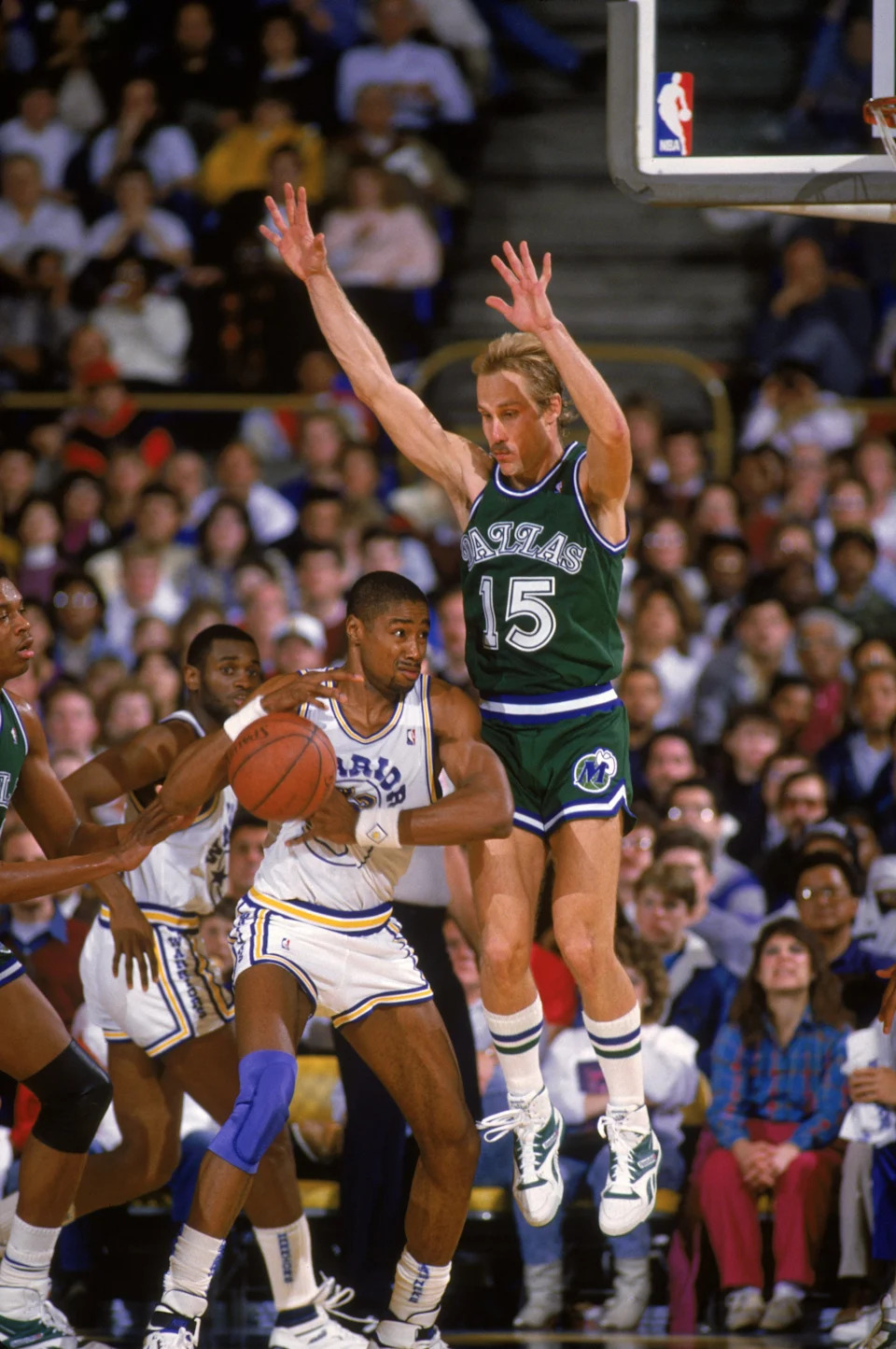 OAKLAND, CALIFORNIA - 1987: Brad Miller #15 of the Dallas Mavericks leaps to defend Rod Higgins #22 of the Golden State Warriors during an NBA game at the Arena in Oakland, California in 1987. NOTE TO USER: User expressly acknowledges and agrees that, by downloading and/or using this Photograph, User is consenting to the terms and conditions of the Getty Images License Agreement. Mandatory copyright notice : Copyright 1987. (Photo by Otto Greule Jr/Getty Images)