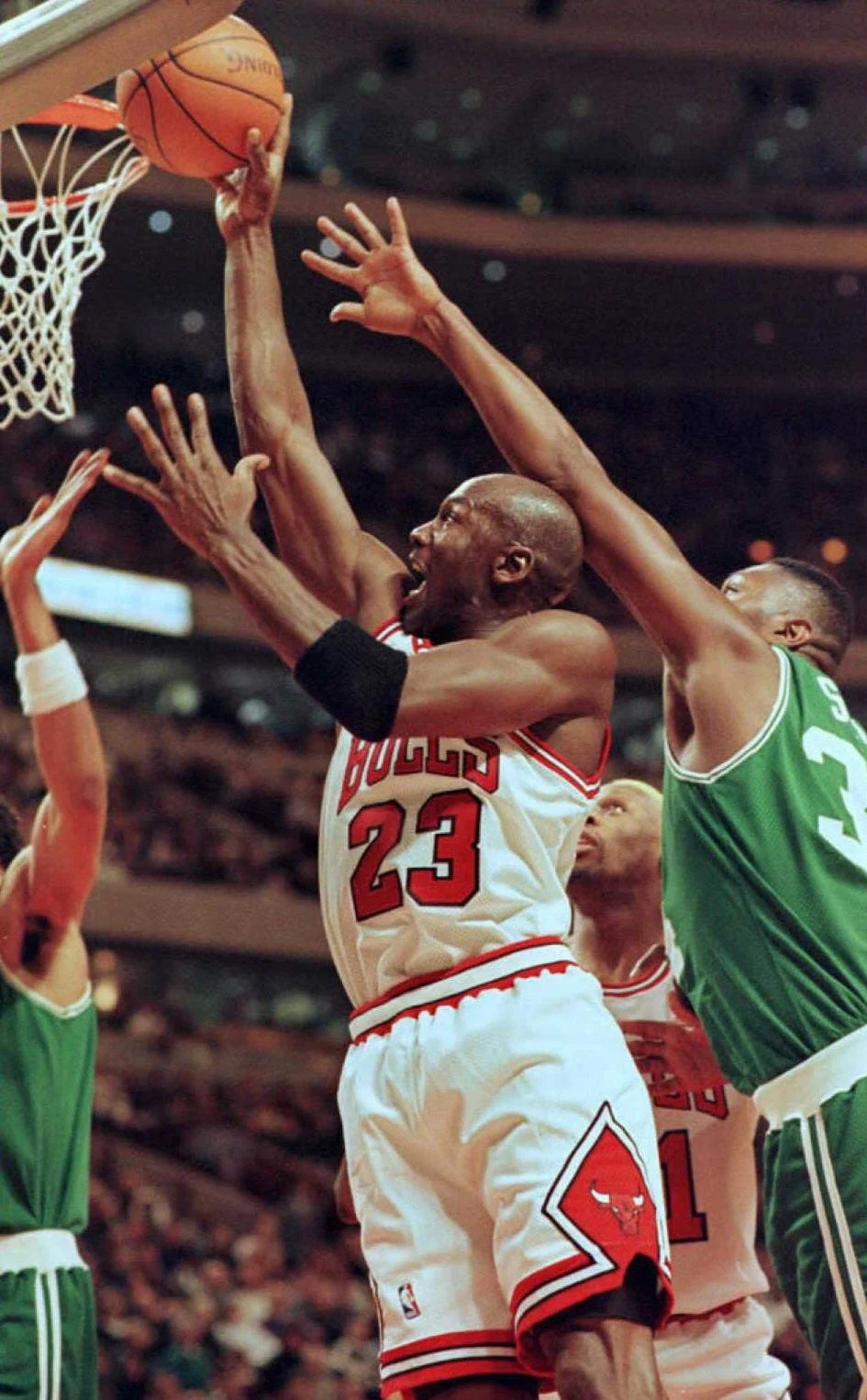 CHICAGO, UNITED STATES: Michael Jordan (23), guard for the Chicago Bulls, glides under Boston Celtics forward Doug Smith (R) to make a basket in the first half of their NBA game at the United Center in Chicago. The Bulls started the game with a 51-6 record fo the season. AFP PHOTO Vincent Laforet (Photo credit should read VINCENT LAFORET/AFP via Getty Images)