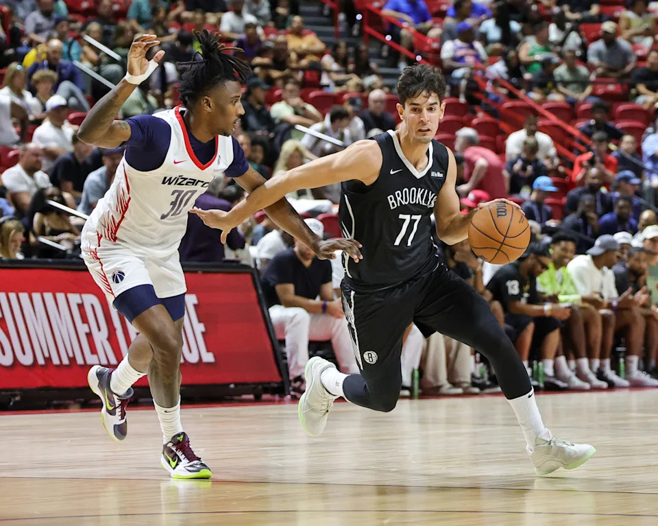LAS VEGAS, NEVADA - JULY 13: Ben Saraf #77 of the Brooklyn Nets drives against Jamir Watkins #30 of the Washington Wizards in the first half of a 2025 NBA Summer League game at the Thomas & Mack Center on July 13, 2025 in Las Vegas, Nevada. NOTE TO USER: User expressly acknowledges and agrees that, by downloading and or using this photograph, User is consenting to the terms and conditions of the Getty Images License Agreement. (Photo by Ethan Miller/Getty Images)