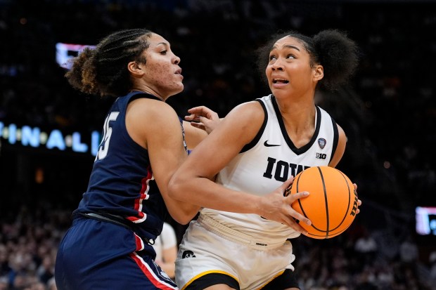 Iowa forward Hannah Stuelke drives around UConn forward Ice Brady, left, during the second half of a Final Four college basketball game in the women's NCAA Tournament, Friday, April 5, 2024, in Cleveland. (AP Photo/Morry Gash)