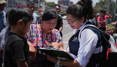 A relative of an unaccompanied minor deported from the United States reviews the list of those deported outside La Aurora International Airport, in Guatemala City, Sunday, Aug. 31, 2025. (AP Photo/Moises Castillo)