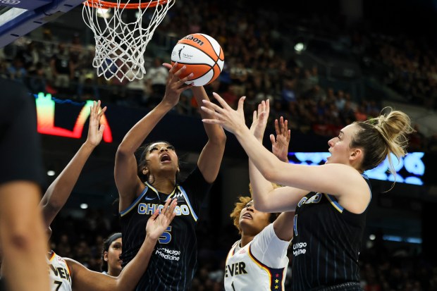 Sky forward Angel Reese battles for a rebound against the...